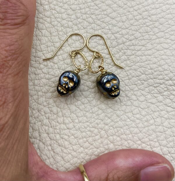 small black skull earrings on gold hoop
